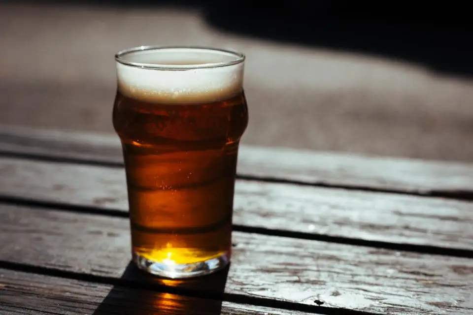 A pint of amber ale on a weathered wood table